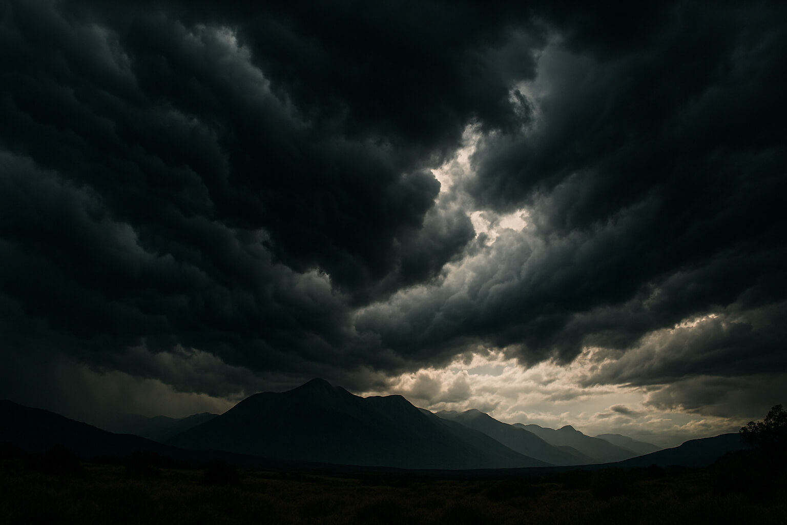 Wide-angle photo of dramatic storm clouds over mountains with rich contrast and dynamic lighting.